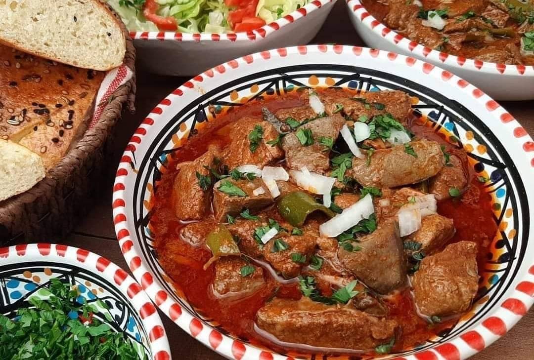 Ragoût tunisien dans un bol peint, avec du pain et de la salade